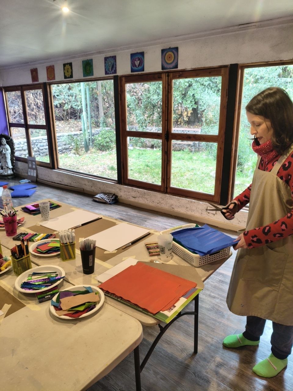 Tallerista cortando telas de colores sobre la mesa